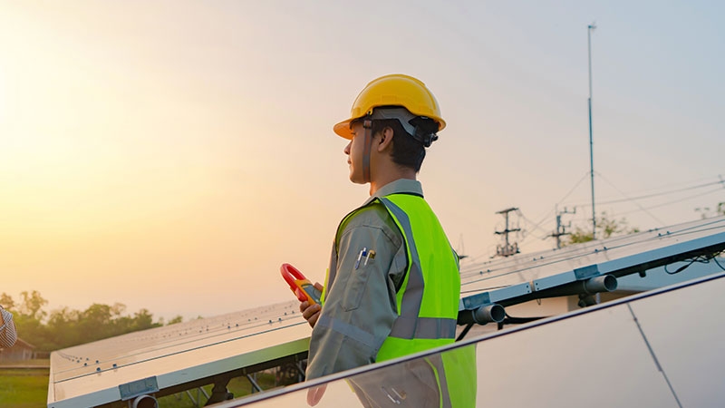 Engineer with solar panels or solar cells on the roof in farm