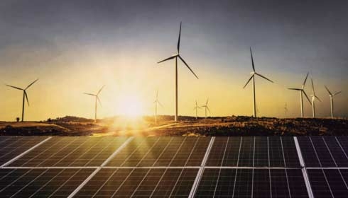 Solar panels with wind turbine and sunset.