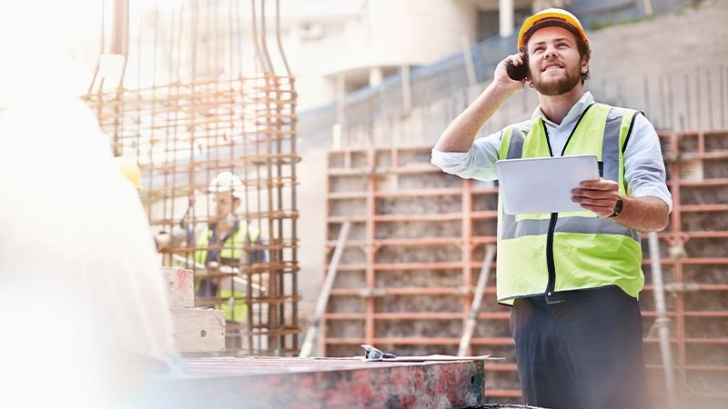 A person in a safety vest talking on the phone