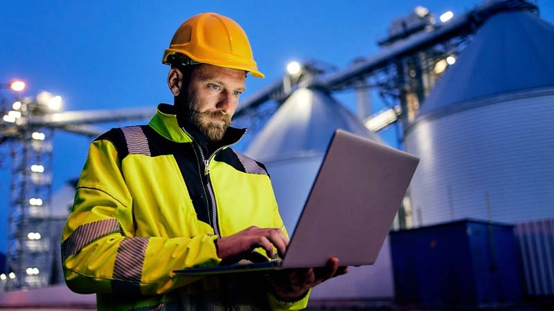 A person in a hard hat using a computer