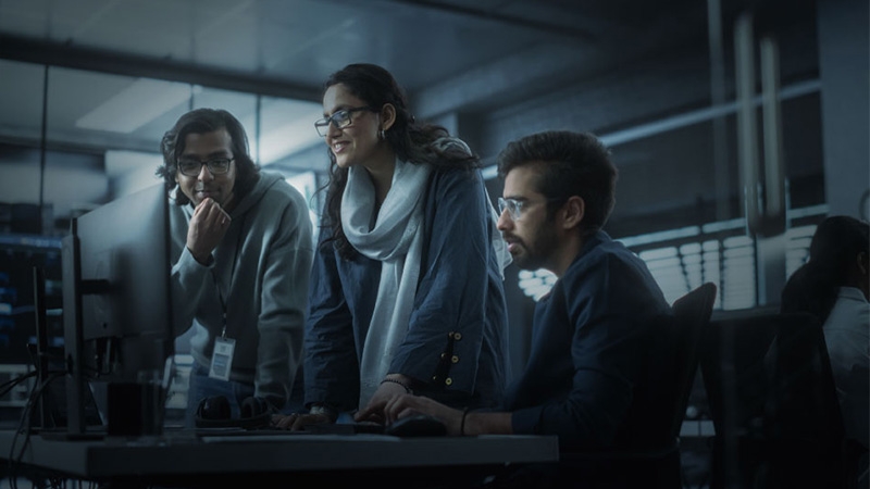 Three people looking at the computer screen