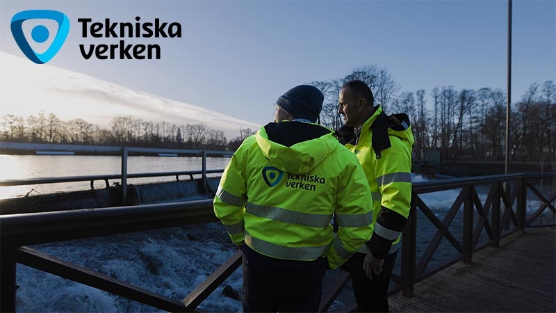 Men in bright yellow jackets standing next to a railing