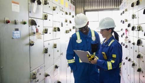 Workers reviewing paperwork in gas plant