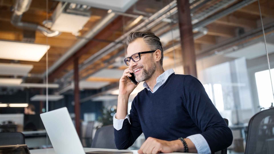 man talking to someone while using laptop