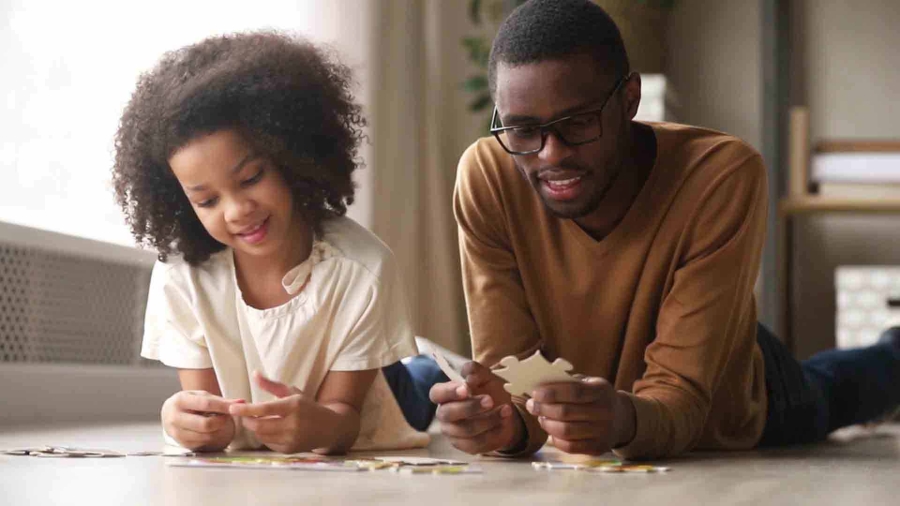 man with his daughter holding a puzzle piece