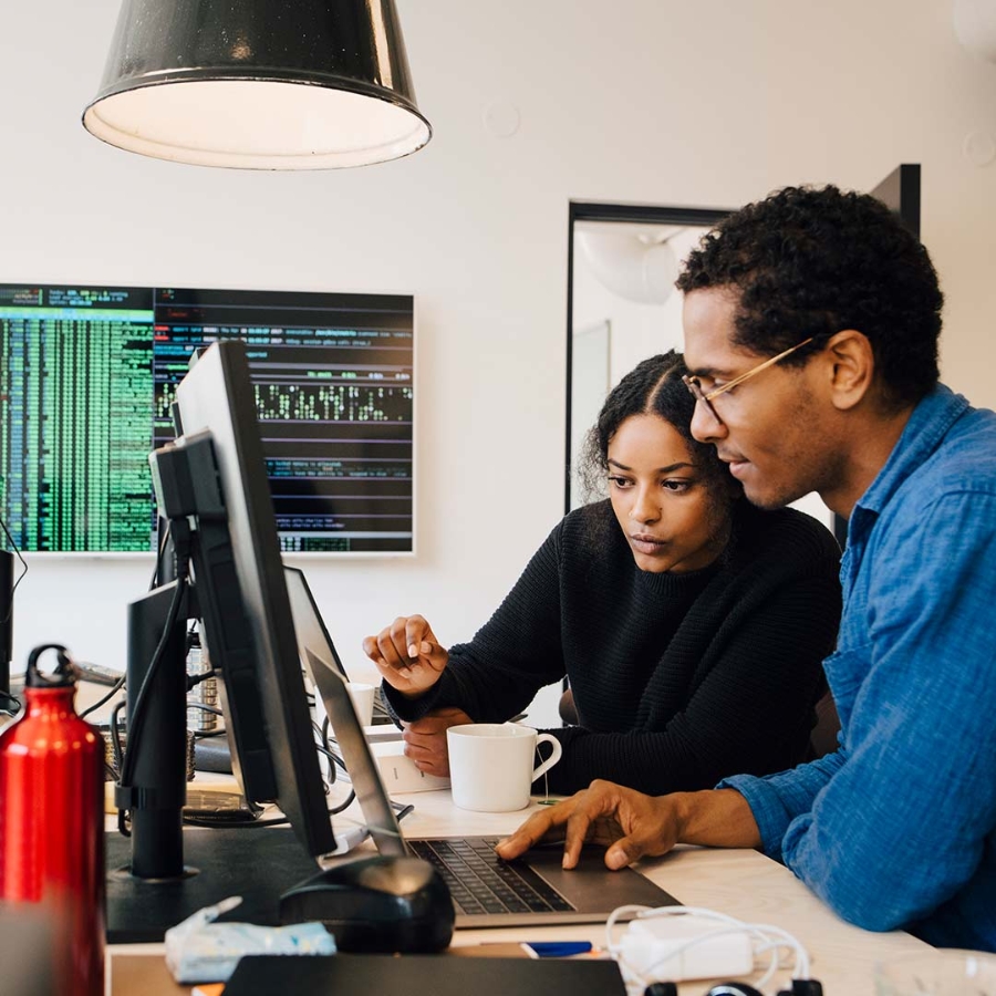 A male and a female employee discussing in office