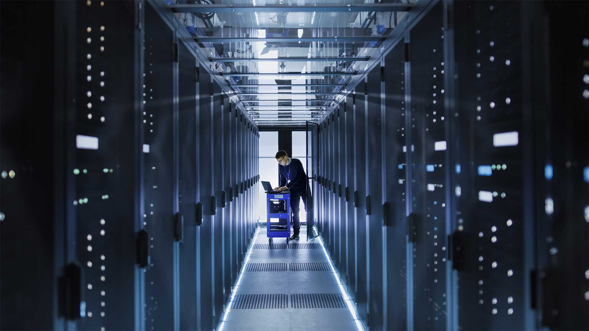 A person standing in a hallway with a computer