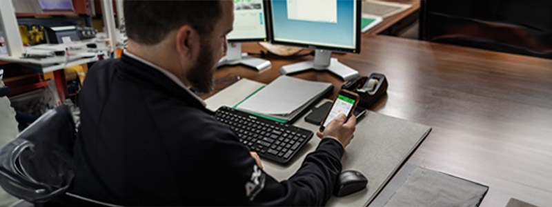 A person sitting at a desk using a phone