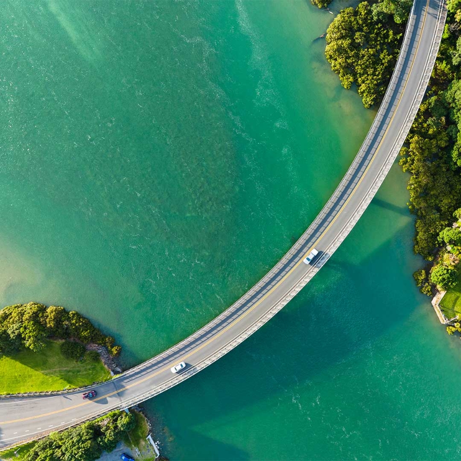 A bridge over water with trees and land