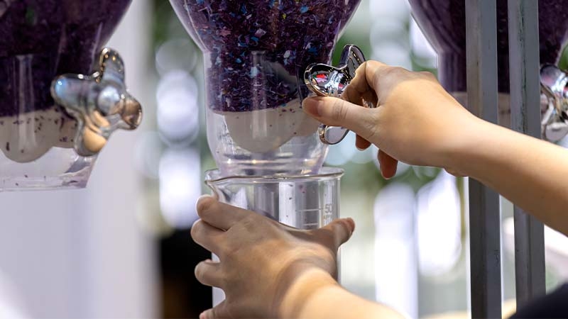 A person's hands holding a large glass container