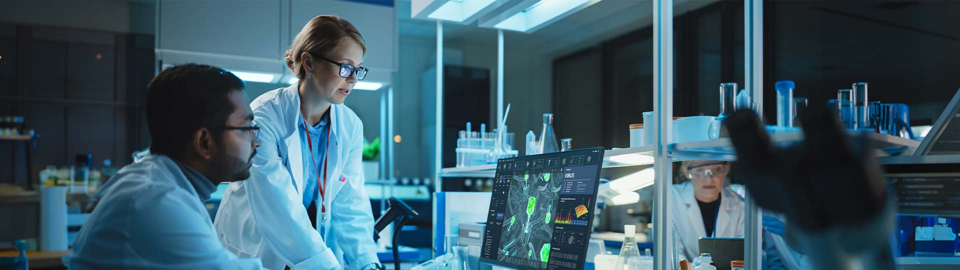 A person in a lab coat looking at a computer