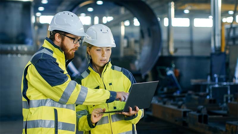 A person and person wearing hardhats and reflective jackets