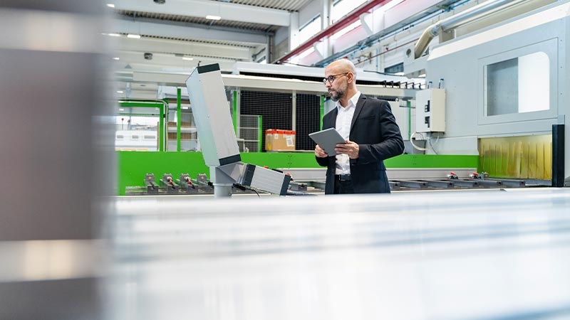 A person holding a tablet in a factory