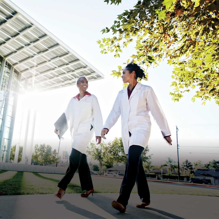 A few women in lab coats walking