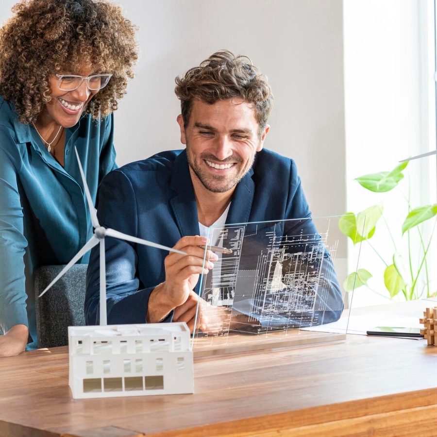 Two business partners in modern office looking at futuristic screen