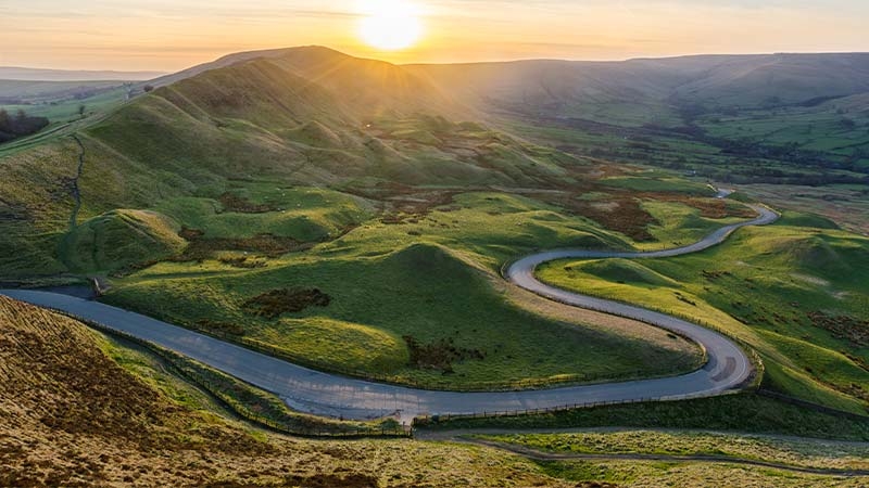 A road going through a green valley