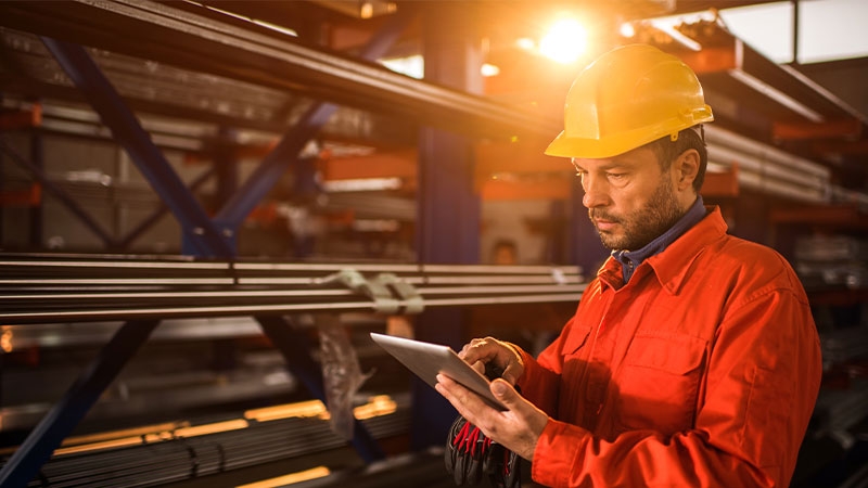 A person in a hard hat using a tablet