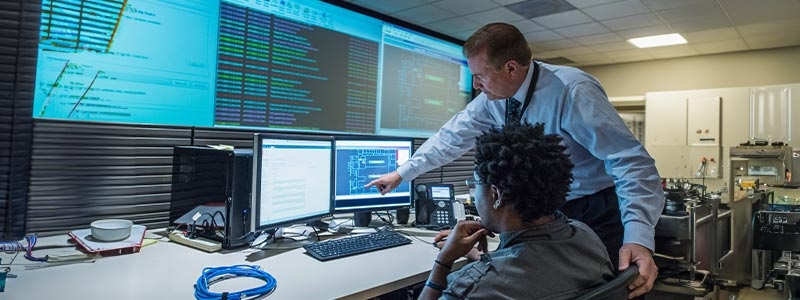 A person pointing at a computer screen