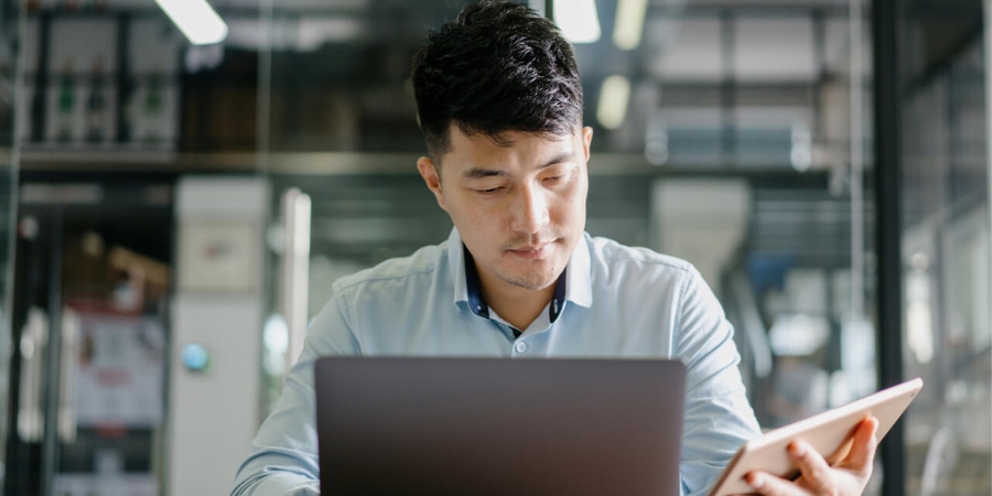 man working on laptop and tablet