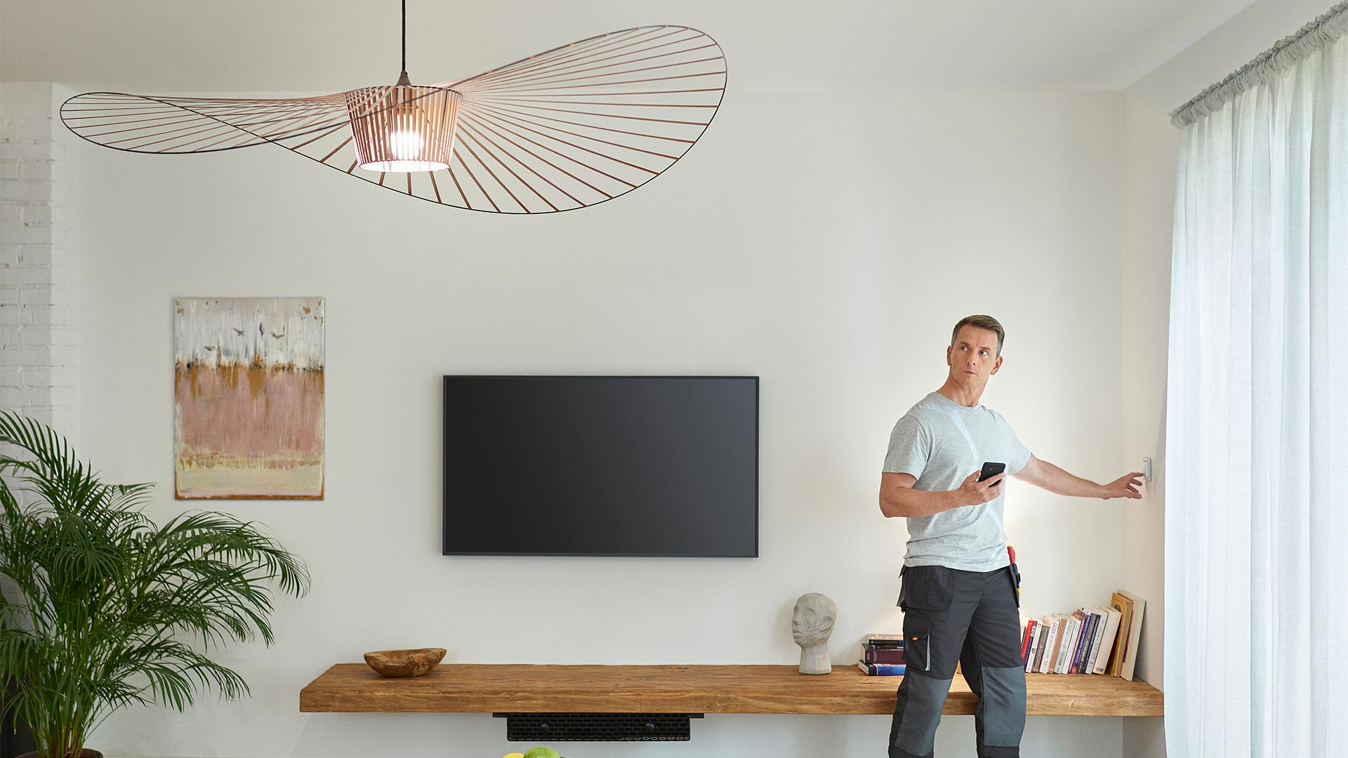 Man using Wiser switches to switch on light