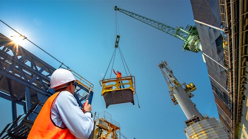 A person in a hard hat holding a crane