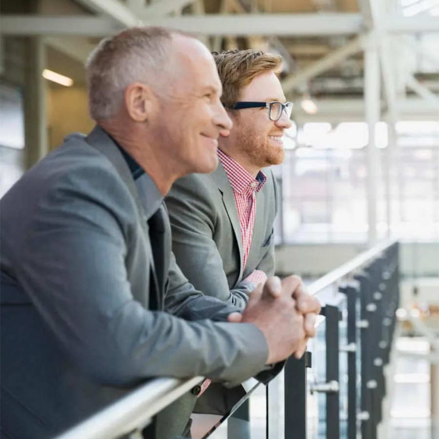 A group of men leaning on a railing