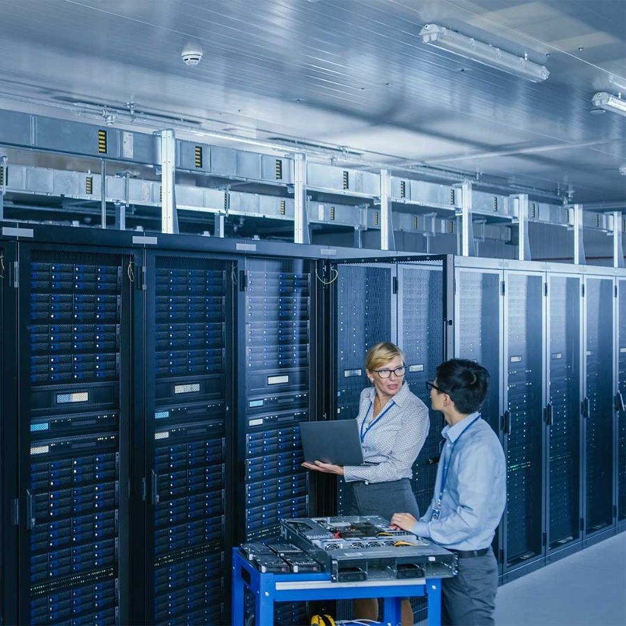 A person and person standing in a room with a computer