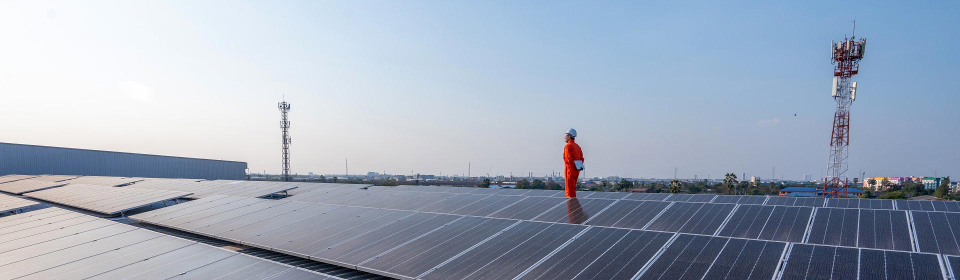 A person standing on a roof of solar panels