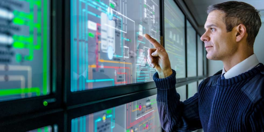 設施經理在工業能源管理的多螢幕檢視畫面上使用能源監控軟體。