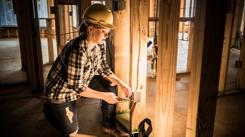 A person wearing a hard hat and holding a box