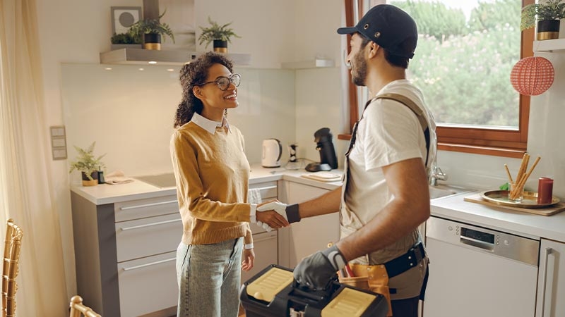 A person and person shaking hands in a kitchen