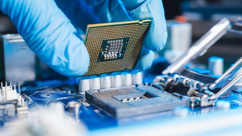 technician laying semiconductor-based CPU in the motherboard socket