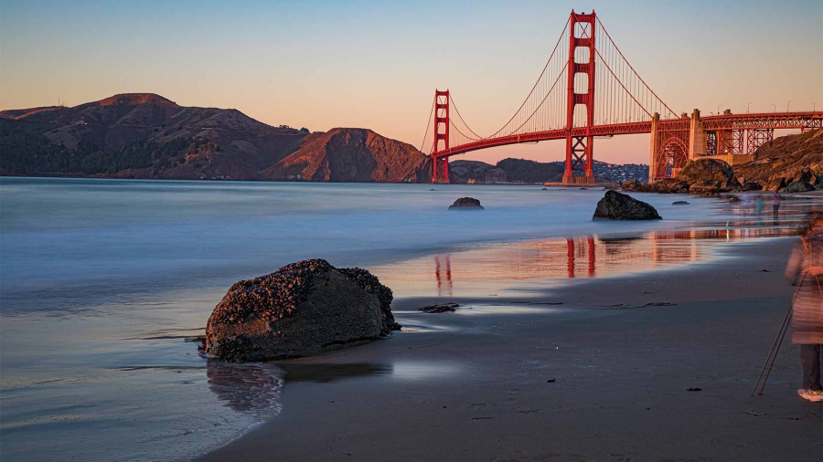 A bridge over water with rocks and a body of water