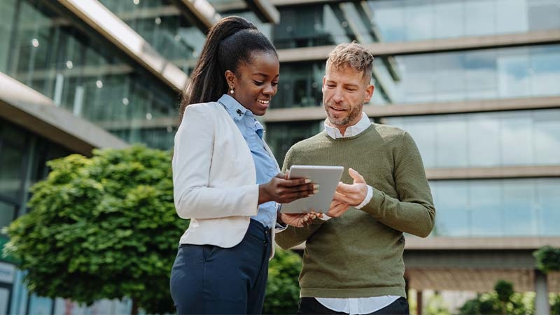 A person and person looking at a tablet