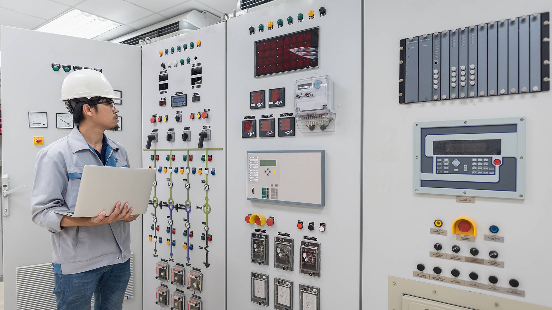 a young male engineer working at substation room of power plant