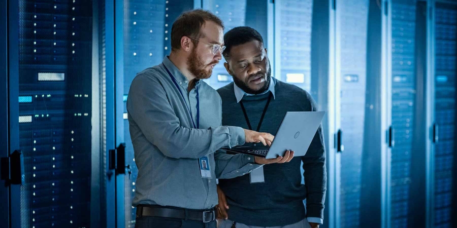 Two male employees discussing inside a data center