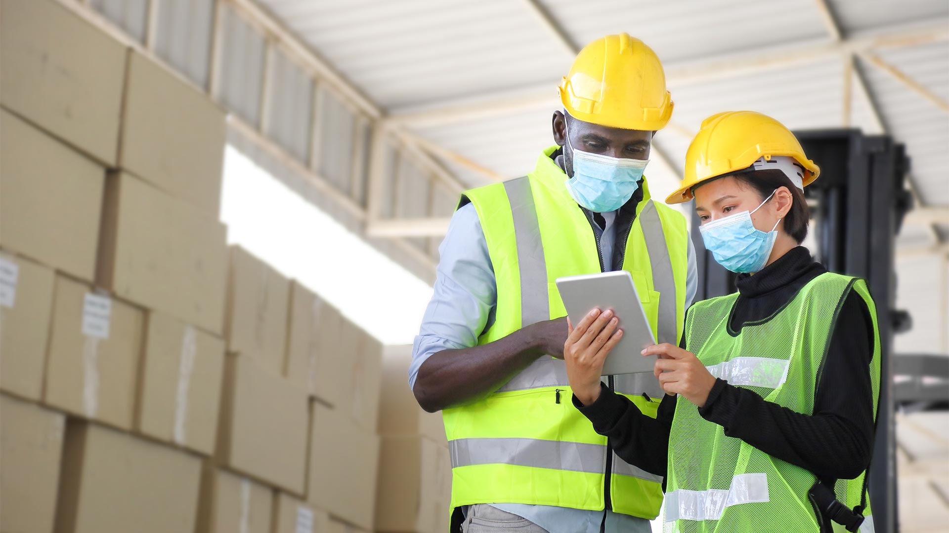 two workers with helmets and tablet