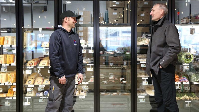 A couple of men standing in front of a glass case