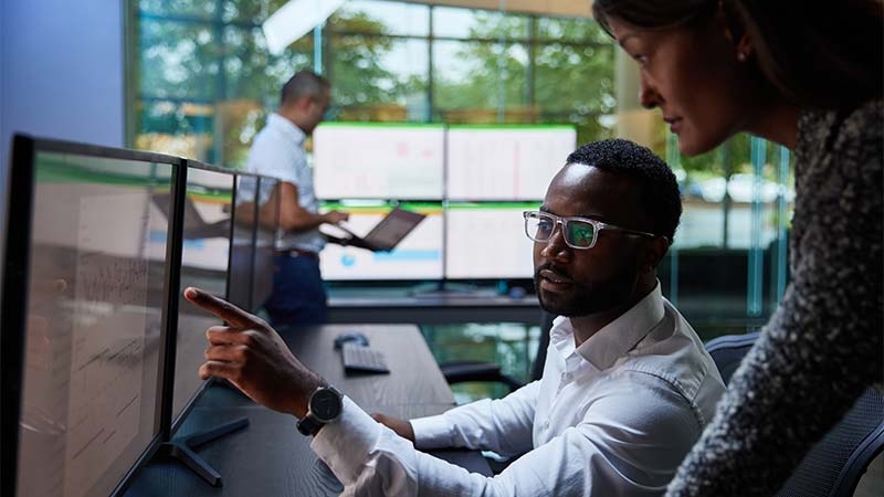 A person and person looking at a computer screen