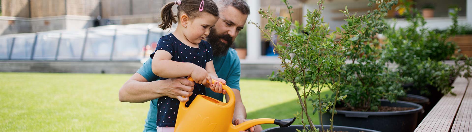 A person and a child watering plants