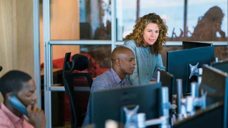 A person and person looking at computers