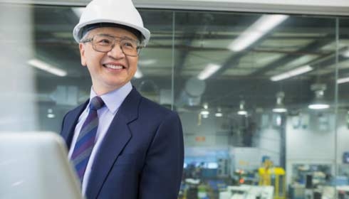 Smiling manager using laptop in factory