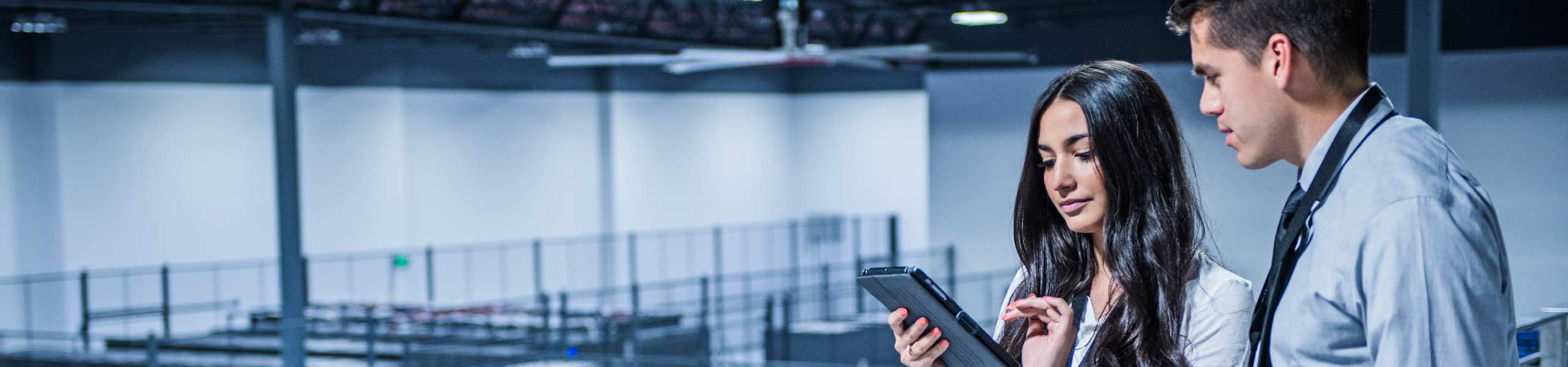 Man and a woman in a data center using a tablet device