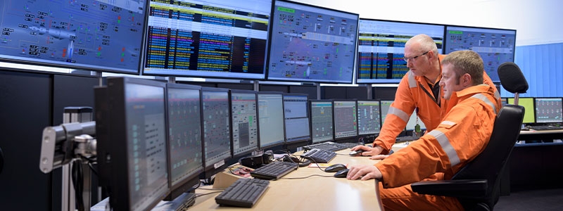 A person sitting in front of several monitors