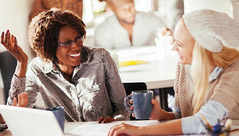 A person smiling while holding a mug interior Designers